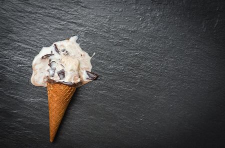 ice cream cone vanilla with chocolate dripping flowing on dark background , Flat lay / ice cream melting scoops and sweet dessertの写真素材