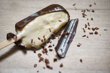 melting ice cream stick and and lolly sweet dessert / ice cream vanilla covered chocolate on wooden background , selective focusの写真素材