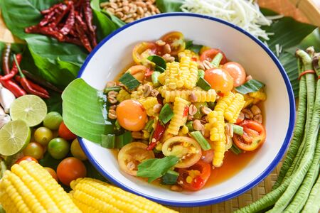 salad corn spicy with fresh vegetables herbs and spices ingredients with chilli tomato peanut garlic served on plate / Corn Salad Papaya Som tum Thai menu Asianの写真素材
