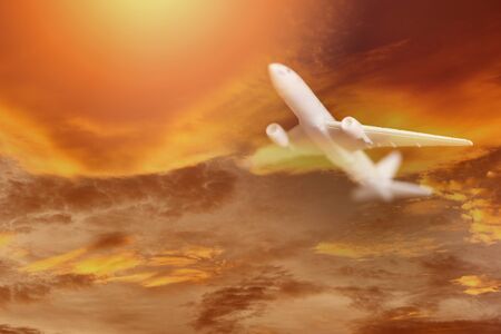 Airplane storm flying in the orange sky with clouds at colorful sunset Travel background /...
