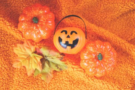 Halloween decoration accessories holiday with  pumpkin jack o lantern and leaves autumn on orange towel / halloween background top viewの写真素材