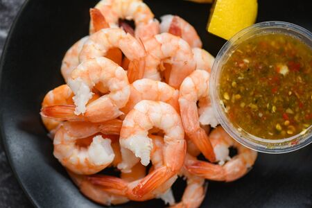 fresh shrimps served on plate with seafood sauce / boiled peeled shrimp prawns cooked in the restaurantの写真素材
