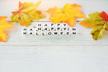 Halloween background with word blocks happy halloween decorations and leaves autumn on white wooden table holiday concept , top view copy spaceの写真素材