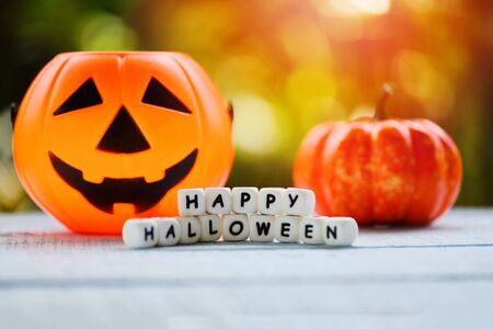 Halloween background with word blocks happy halloween decorations and pumpkin jack o lantern funny spooky on wooden table happy holiday conceptの写真素材