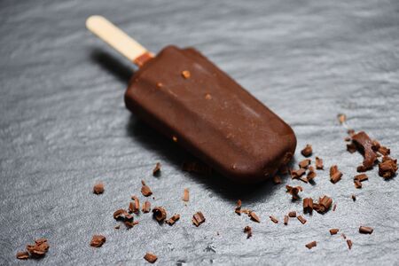 ice cream stick with nut almonds on dark background , Flat lay / ice cream covered chocolate sticks frozen ice cream and Lolly sweet dessertの写真素材