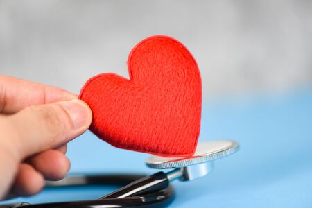 Insurance Health concept / Stethoscope and red heart healthcare on blue background , hands holding red heart take care health love give hope donate to societyの写真素材