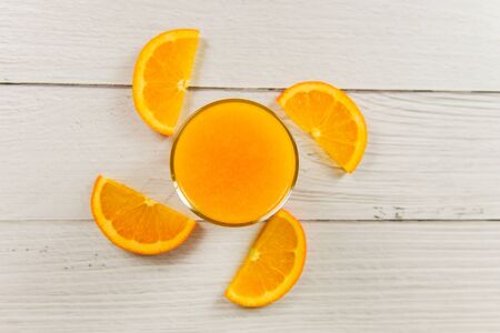 Orange juice in the glass and fresh orange fruit slice on wooden tableの写真素材