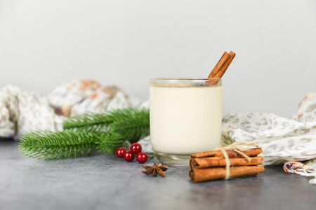 Eggnog delicious holiday drinks like themed parties with cinnamon pine cone and red ball for Traditional Christmas and winter holidays Homemade eggnog in glasses pine branch decorated table の写真素材