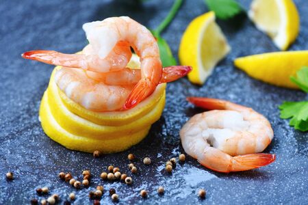 Seafood boiled peeled shrimp prawns cooked with spices and vegetable / Fresh shrimps served on lemonの写真素材