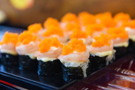 Japanese food shrimp sushi roll rice with tobiko egg is orange (flying fish roe) nori in the restaurant sushi menu set japanese cuisine fresh ingredients on tray , selective focusの写真素材