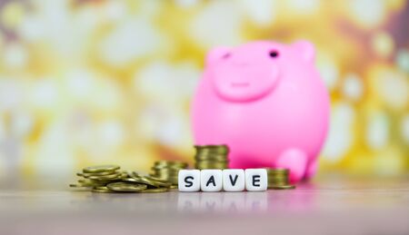 Concept of save money coin stack growing business or investment or scholarship / Save money and piggy bank on the wooden table bokeh background の写真素材