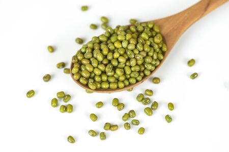 Mung beans on wooden spoon on white background / Bean seed cereal whole grains の写真素材