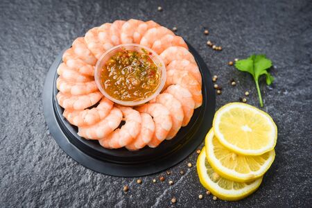 fresh shrimps served on plate with seafood sauce boiled peeled shrimp prawns with ice in the restaurantの写真素材