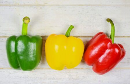 Colorful green, red and yellow peppers paprika on wood background bell pepperの写真素材