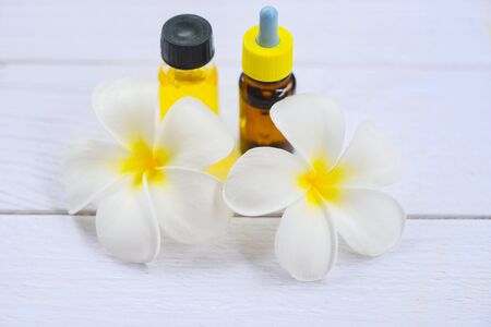Aromatherapy herbal oil bottles aroma with white flower Frangipani Plumeriaon / Essential oils natural on wooden table and organic minimalistの写真素材