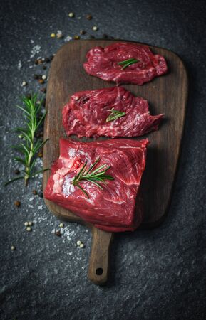 Raw beef steak with herb and spices / Fresh meat beef sliced on wooden cutting board backgroundの写真素材