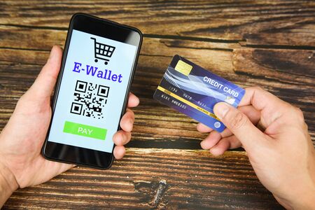 hand holding credit card and e wallet app on smartphone technology pay / payment online shopping paying with technology e wallet conceptの写真素材
