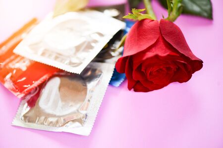 Birth Control with Condom and roses flower love on pink background -  pregnancy or sexually transmitted disease / Condom Prevent Pregnancy Contraception Valentines safe sex conceptの写真素材