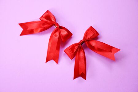 Red ribbon bow on pink background / Two gift bow hairpin perfect holiday handmadeの写真素材