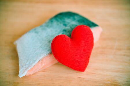 Wedding food with heart on fresh raw salmon steak fish on wood background / romantic love valentines day and love cooking food  conceptの写真素材