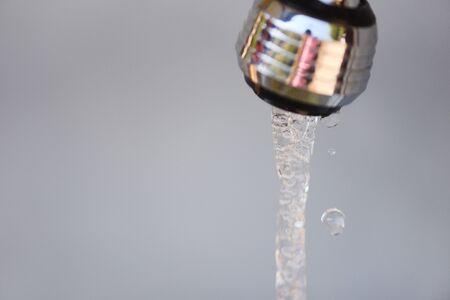 Water tap / Water drop from faucet on gray background , selective focus
