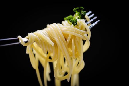 Spaghetti on fork and black background / spaghetti italian pasta with parsley in the restaurant...