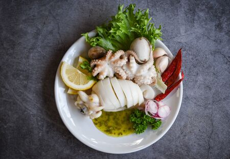 Cooked food squids octopus or cuttlefish at seafood restaurant / Squid salad spices lemon garlic chili sauce on white plate backgroundの写真素材