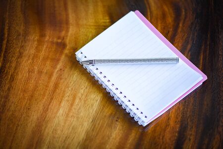 Sketch book with pen or notebook blank pages on wood background / notebook paper business office...
