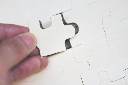 Business man holding jigsaw puzzle / Close up of jigsaw pieces for joining and trying to connect business partnership conceptの写真素材