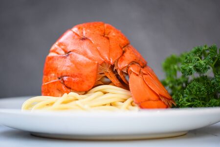 Spaghetti seafood lobster food on a white plate / spaghetti shrimp dinner with herb spices lemon...