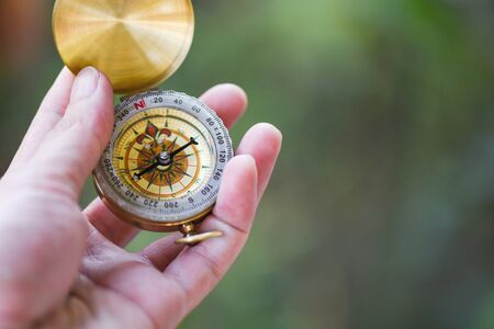 Man explorer searching direction with compass for map / Navigational compass travel and tourist...