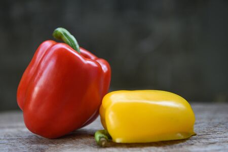 Yellow and red bell pepper / Fresh sweet pepper bell on wood backgroundの写真素材