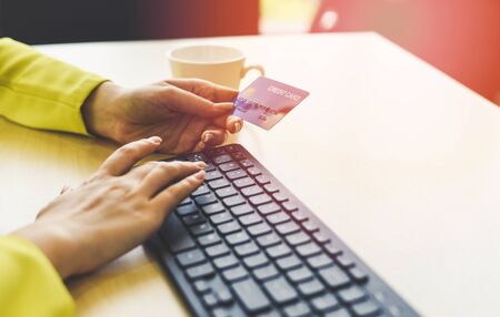 Business woman holding credit card payment and using keyboard computer in a office / payment online shopping paying with credit card technology e wallet conceptの写真素材