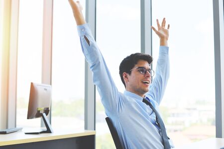 Celebrating success businessman win in his business startup in a office / Business man happy completed job and Successful deal の写真素材