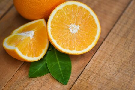 Fresh orange slice half and orange leaf healthy fruits harvest concept / Orange fruit on wooden...