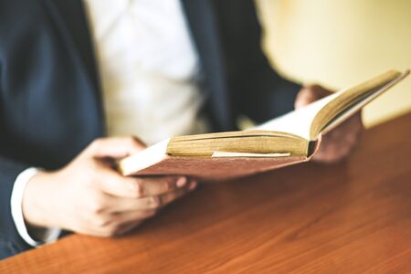 Business man or student holding a book on hand / Business education study concept man reading book on the table の写真素材