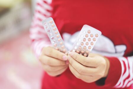 Contraception pills in hand woman holding / Birth control contraceptive means prevent pregnancyの写真素材