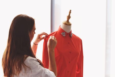 Fashion designer studio measuring textile material cutting sewing fabric by woman designer stylish showroom / designer working professional measuring a clothing for tailoring mannequins in workshopの写真素材