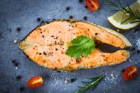 Salmon fish fillet steak seafood / Grilled salmon steak with herbs and spices rosemary lemon on dark background , top viewの写真素材