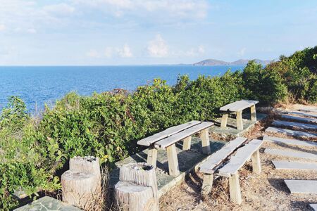 Bench on top hill for viewpoint the sea with tree / mountains view with sea in the thailandの写真素材