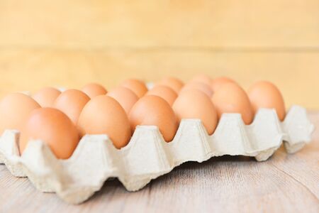 Eggs in egg box on wooden background / Close up of raw chicken eggs organic food 