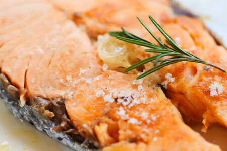 Salmon steak with herbs and spices rosemary on plate background / Close up cooked salmon fish fillet steak seafoodの写真素材