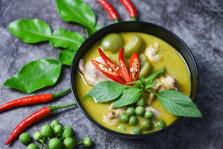 Green curry chicken cuisine asian food on the table / Thai food green curry on soup bowl with ingredient herb vegetable on dark plate backgroundの写真素材