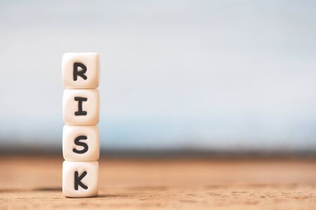 Risk concept with block risk stacked on wooden table background の写真素材