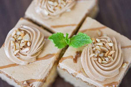 Close up coffee cake delicious dessert  with mint leaf and nuts topping , top view の写真素材