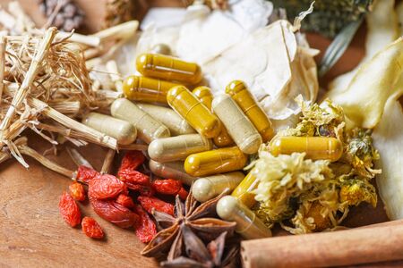 Herbal medicine capsules and dried herb from nature Non-toxic organic product on wooden background / Dry spices and herbs food ingredients in Thailand Asian for healthy lifestyleの写真素材