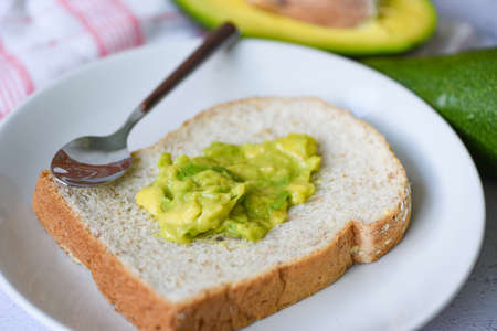 Avocado dip mashed / avocado toast on white plate background fruits healthy food conceptの写真素材