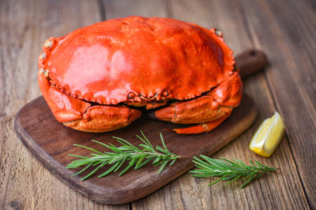Fresh crab with ingredients lemon rosemary on wooden board / Seafood shellfish Steamed red crab or Boiled stone crabの写真素材