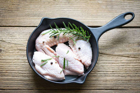 Raw chicken wings, herbs and spices with pepper chili for cooking thai asian food rosemary chicken, top view.の写真素材