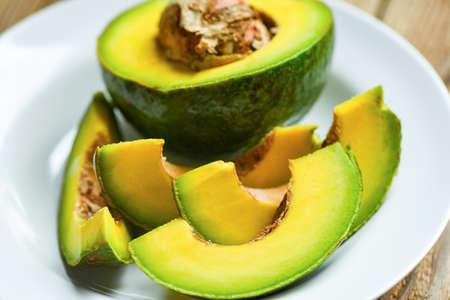 Avocado fruit and slice cut halfs avocado on white plate background, Fruits healthy food concept.